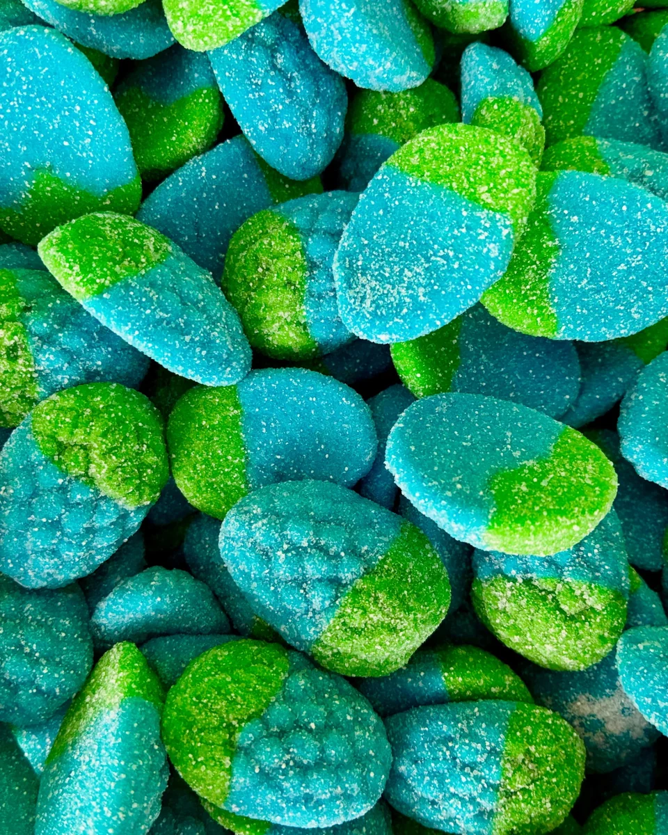 A close-up of bright blue and green sugar-coated gummy candies.